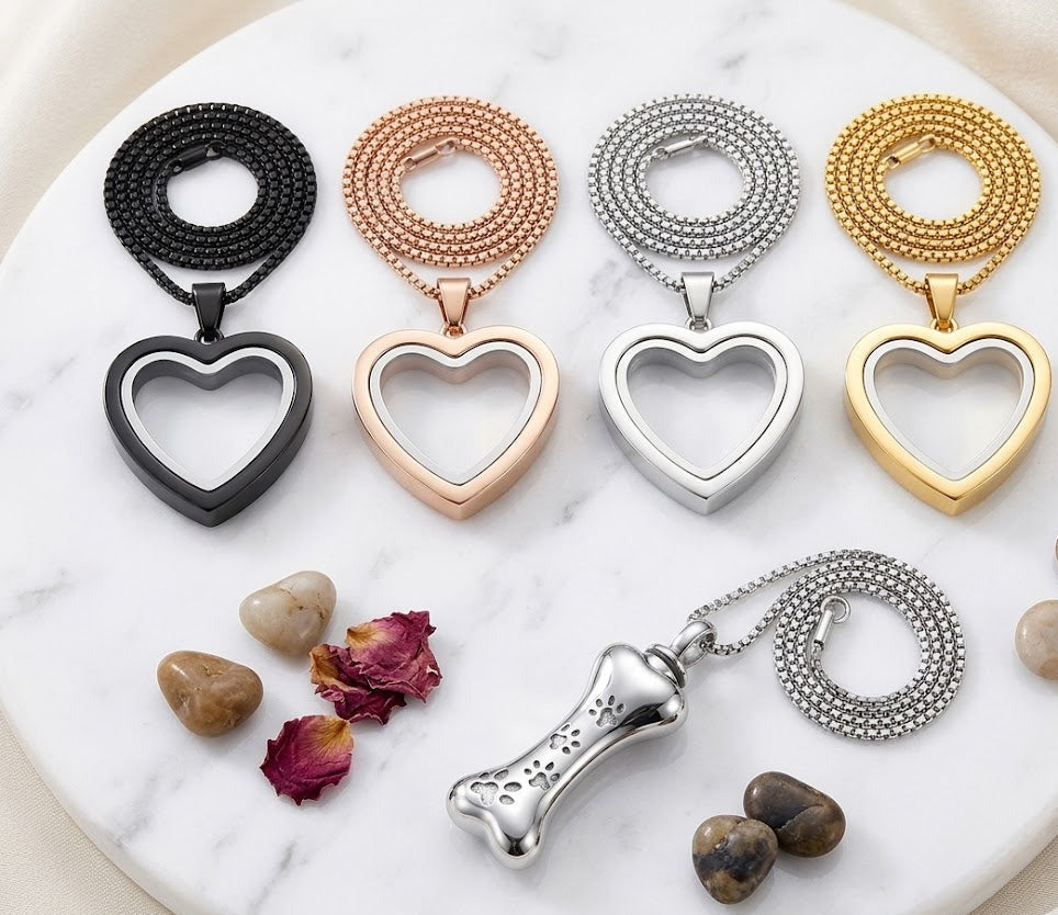 Collection of heart-shaped and bone-shaped pendants on a marble surface with dried flowers and stones.